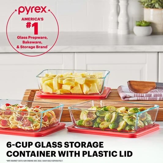 Pyrex glass storage containers with plastic lids on a kitchen counter.