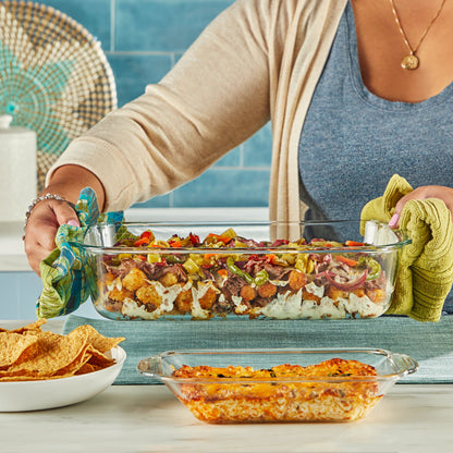 Pyrex 9x13 casserole being held by woman at counter