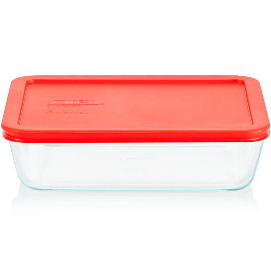 Clear glass food storage container with a red lid on a white background