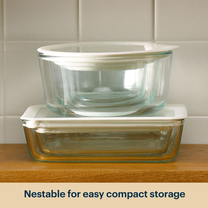 Stacked Pyrex glass storage containers with clear lids.
