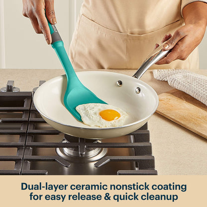 Person cooking an egg in a frying pan with a turquoise spatula, kitchen setting.